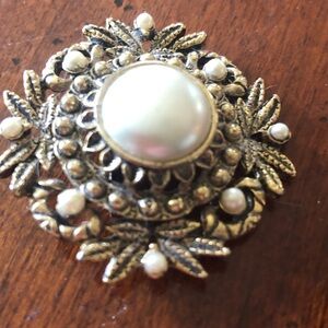 vintage antiqued gold-tone filigree brooch featuring a large central faux pearl